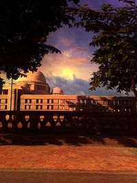 View of buildings against cloudy sky at sunset