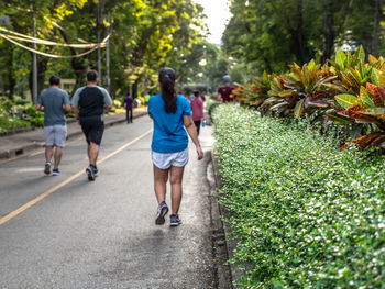 Rear view of people walking on footpath