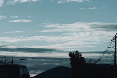 Low angle view of silhouette trees against sky