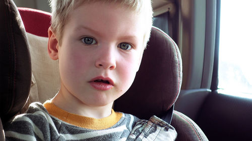 Portrait of cute boy sitting in car