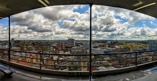 Panoramic view of buildings against sky seen through glass window