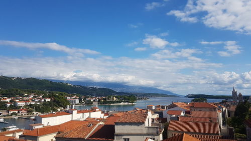 High angle view of townscape by sea against sky