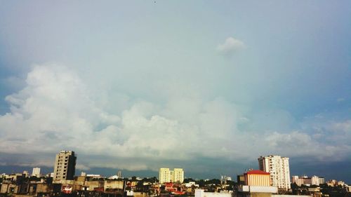 Buildings in city against cloudy sky