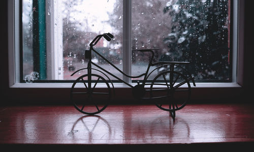 Toy bicycle on window sill at home