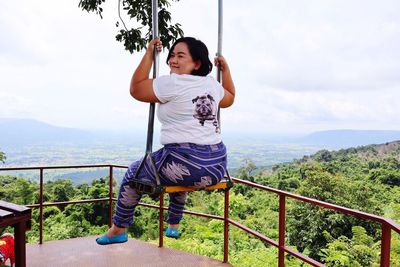 Full length of woman on railing against sky