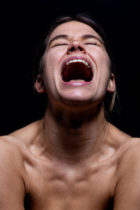 Portrait of shirtless mid adult man against black background