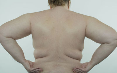 Rear view of shirtless man against white background