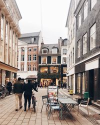 People on street amidst buildings in city