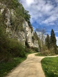 Road amidst trees against sky