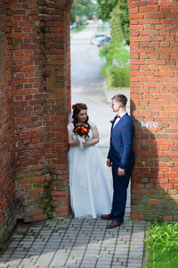 Bride and groom standing at archway