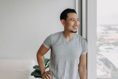 Portrait of young man standing at home