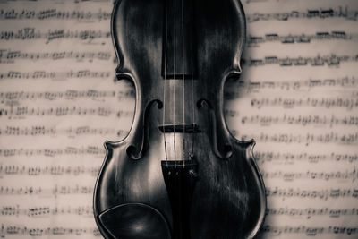 Close-up of violino againt open sheet music 