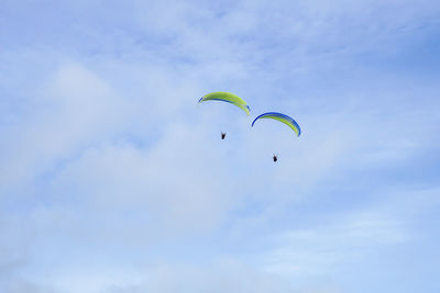 Low angle view of person paragliding against sky