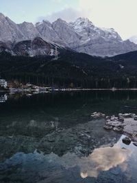 Scenic view of lake by snowcapped mountains against sky