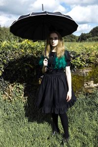 Portrait of smiling young woman standing against sky