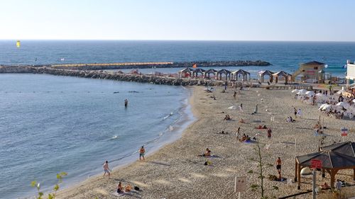Group of people on beach against sky