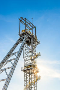 Low angle view of crane against clear blue sky