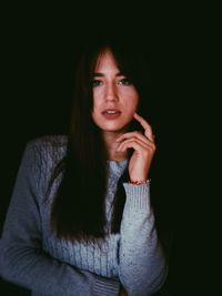 Portrait of a beautiful young woman over black background