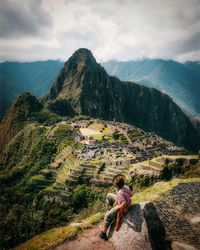 Rear view of woman looking at mountains against sky