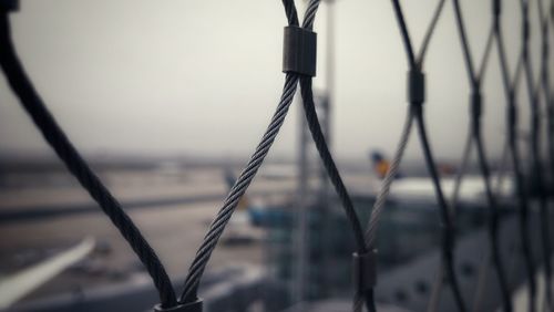 Close-up of barbed wire fence against blurred background