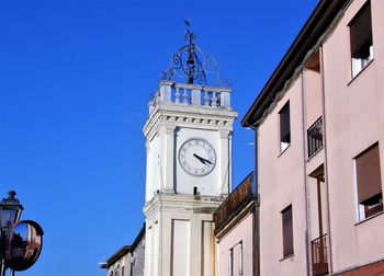 Low angle view of clock tower against blue sky