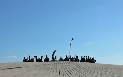 Low angle view of statues against blue sky