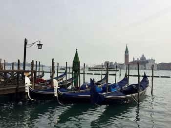 Boats moored in sea against sky