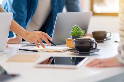 Midsection of business people working on table