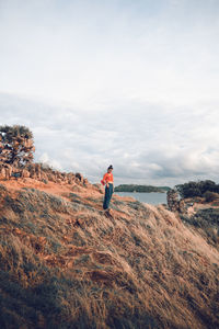 Woman standing on mountain against sky