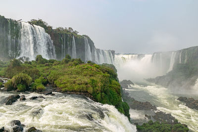 Scenic view of waterfall against sky