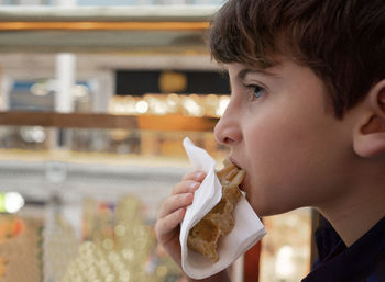 Caucasian kid enjoying a waffle.