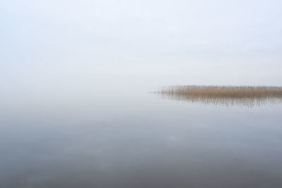 Scenic view of lake against sky during winter