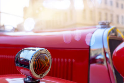 Sharply focused indicator of a red vintage car, deliberately blurred in the background, bokeh