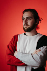 Portrait of young man against red background