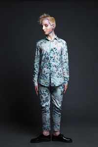 Young woman standing against black background