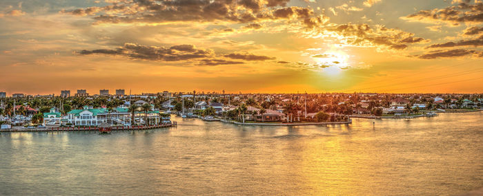 Golden sky over city lights across factory bay in marco island, florida.