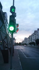 Road sign in city against sky