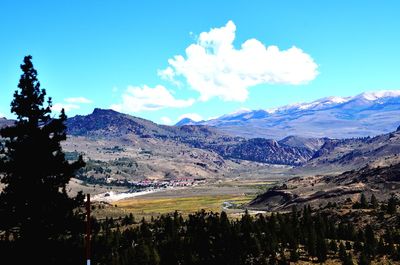 Scenic view of landscape and mountains against blue sky