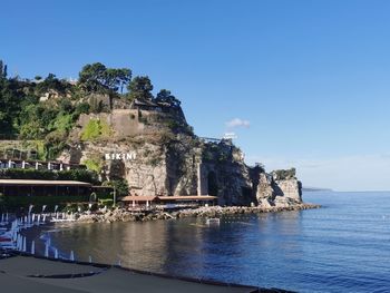 Scenic view of sea by buildings against sky