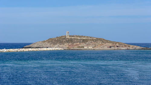 Lighthouse by sea against sky