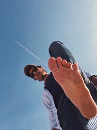 Low angle view of man with barefoot against sky