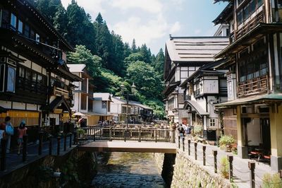 Canal amidst buildings in city against sky