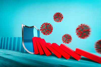 Close-up of red paint on table against blue background