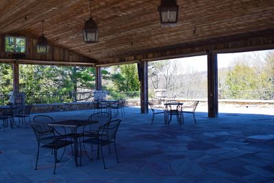 Empty chairs and tables in restaurant against building