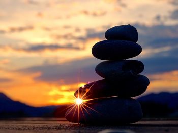 Stack of stones on beach during sunset