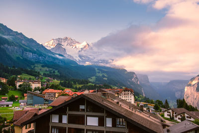 Town by mountains against sky during sunset