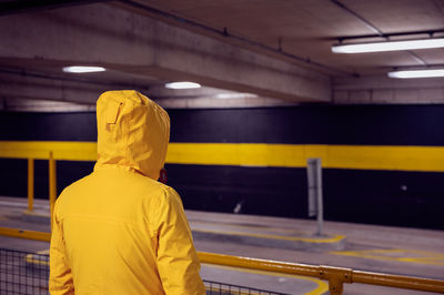 Rear view of man standing at subway station