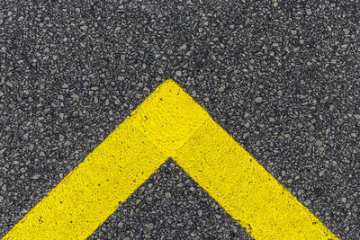 High angle view of yellow arrow symbol on road