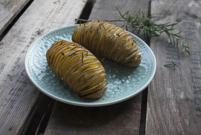 Close-up of hasselback potatoes with rosemary served in plate
