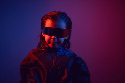 Portrait cyberpunk boy child in vr glasses in blue and red tones. game, virtual reality